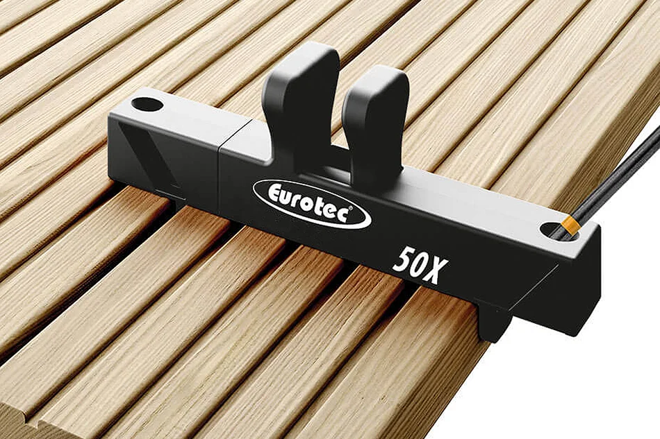 Uchwyt EUROTEC DrillTool 50X ustawiony na desce tarasowej podczas prowadzenia wkrętu